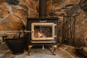 a stove with a fire in a stone wall at Lovers nest by Casa Oso with private hiking trails and pond in Mariposa