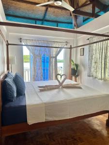 a bedroom with a large bed with a window at Casa Osmena, Culion in Culion Reservation