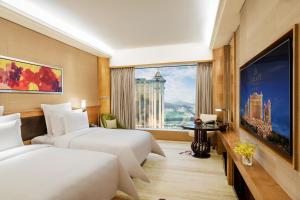 a hotel room with two beds and a large window at Galaxy Macau in Macau
