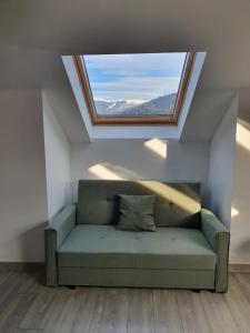 a green couch in a room with a window at FAMILY STUDIO in Sinaia