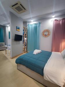 - une chambre avec un lit, une télévision et des rideaux bleus dans l'établissement LAIOLA APARTMENT, à Tirana