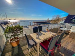 einen Tisch und Stühle auf einer Terrasse mit Blick auf das Wasser in der Unterkunft Haus Putbus in Altefähr - WG 3 mit Panoramablick in Altefähr