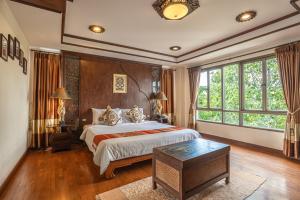 a bedroom with a large bed and a large window at Jirung Health Village in Mae Rim