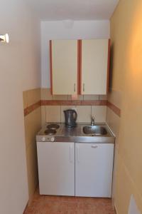 a small kitchen with white cabinets and a sink at Apartments Palace Mira Mare in Tivat