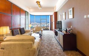 een woonkamer met banken en een televisie in een hotelkamer bij Empark Grand Hotel Kunming in Kunming