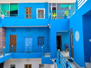 a blue building with people on the balcony at Namaste Caffe-for heritage stay in Jodhpur