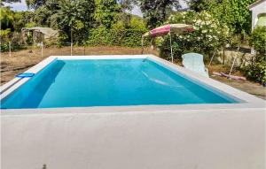 una piscina in un cortile con ombrellone di Pet Friendly Home In Xativa With Kitchenette a Xàtiva