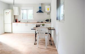 a white kitchen with a table and a white chair at 1 Bedroom Nice Home In Xativa in Xàtiva