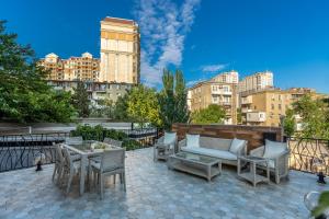 a patio with chairs and a couch and a table at Ivy Garden Hotel Baku in Baku