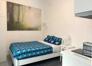1 dormitorio con 1 cama y una pintura en la pared en Campolide Green Door Studio en Lisboa