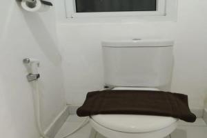 La salle de bains est pourvue de toilettes et d'une couverture brune. dans l'établissement Smart Dream Aeropolis AR2, à Teko