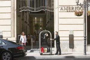 a man with a luggage cart on a city street at Hospes Amérigo, Alicante, a Member of Design Hotels in Alicante