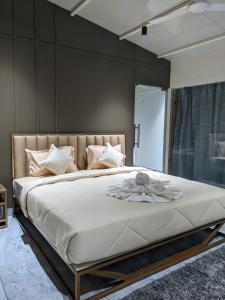 Miracle Hotel and Resorts في كوجيكود: غرفة نوم بسرير كبير عليها شراشف ووسائد بيضاء