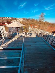 a boardwalk with a table and an umbrella at Jugendstil-Altbauwohnung mit Dachterrasse direkt an der Karlsaue in Kassel