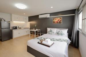 1 dormitorio con 1 cama grande y cocina en DHIresidence at Impact,Muangthongthani en Pak Kret
