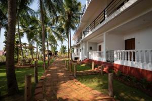a building with palm trees in front of it at De Lavender Luxury sea view Guest Houses in Agonda