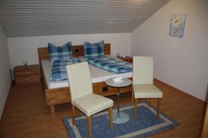 um quarto com uma cama, uma mesa e cadeiras em Große Wohnung in Fürsteneck mit Grill und Terrasse em Fürsteneck