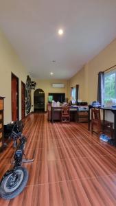 Ban Tai - Nice house in a quiet area 2 min from main road في تونغسالا: غرفة معيشة مع دراجة نارية ملقاة على الأرض