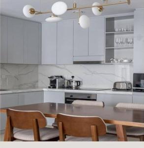 a kitchen with a wooden table and two chairs at Address Beach Resort Fujairah Apartment 2 Bed Rooms and Small Bed Room - Ground Floor 3011 in Al Aqah