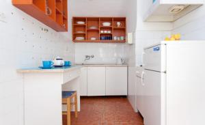 eine Küche mit weißen Schränken und einem Kühlschrank in der Unterkunft Apartment Capitano Blue in Dubrovnik