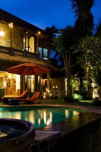 uma casa com uma piscina exterior à noite em Bali Villa Djodji em Ubud