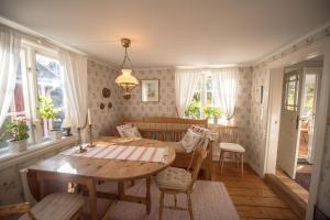 a dining room with a wooden table and chairs at Huset Lövhyddan - SWEEDS Loftahammar in Loftahammar