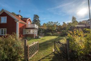 una cerca frente a una casa con un patio en Huset Lövhyddan - SWEEDS Loftahammar, en Loftahammar