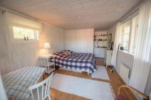 Dormitorio pequeño con cama y mesa en Huset Lövhyddan - SWEEDS Loftahammar, en Loftahammar