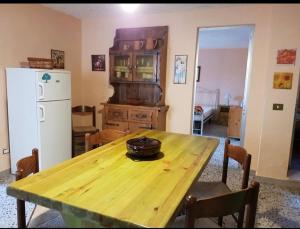 uma cozinha com uma mesa de madeira e um frigorífico branco em Casa vacanze Nietta em Cala Liberotto