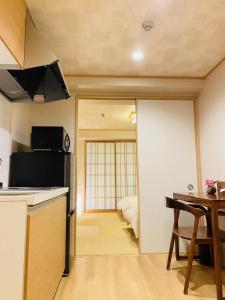 eine kleine Küche mit einem Tisch und einem Esszimmer in der Unterkunft 有秋 双葉 in Osaka