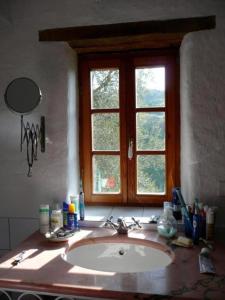 CASA SISSI, Sehnsuchtsort zwischen Olivenhainen في Ranzo-Borgo: منضدة الحمام مع الحوض والنافذة