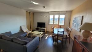 a living room with a couch and a table at Le Cité Internationale Saint Clair in Caluire-et-Cuire