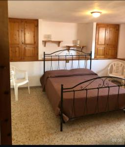 1 dormitorio con 1 cama y 1 silla en Casa vacanze Nietta, en Cala Liberotto