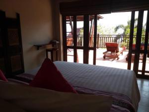 a bedroom with a bed and a view of a patio at Baan KanTiang See Villas - SHA Extra Plus in Ko Lanta