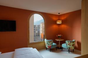 a bedroom with a bed and a table and a window at La Briosa in Bolzano