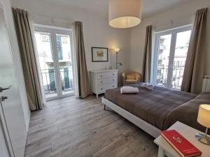 een slaapkamer met een bed, een dressoir en ramen bij Dagnino House - Luxury apartment in the center of Palermo in Palermo