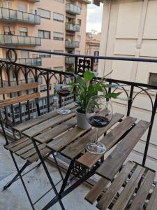 een houten tafel met een glas wijn op een balkon bij Dagnino House - Luxury apartment in the center of Palermo in Palermo