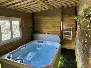 une baignoire jacuzzi dans une pièce en bois avec un arbre dans l'établissement Domaine du Mas de Peyres, à Cavalaire-sur-Mer