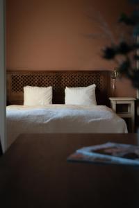 a bedroom with a bed with white sheets and pillows at Grand Hotel Marstrand in Marstrand