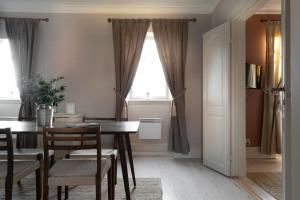 a dining room with a table and chairs and a window at Grand Hotel Marstrand in Marstrand