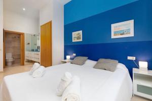 ein blau ummauertes Schlafzimmer mit einem großen weißen Bett in der Unterkunft luxury sea view apartment with 2 rooms in Valencia