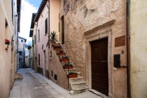 an alley with stairs and potted plants on the side of a building at MancioBiba Home in Trevi