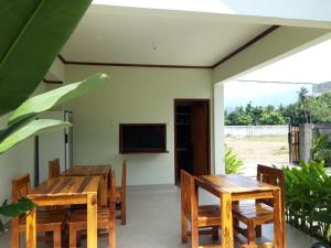 a dining room with wooden tables and chairs and a television at kamala in Selong Belanak