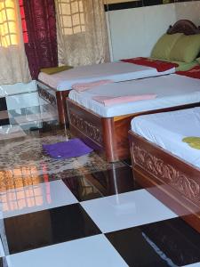 森莫諾隆的住宿－Phanyro Motel，铺有瓷砖地板的客房内的三张床