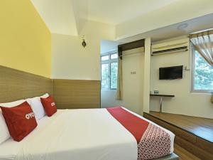 a bedroom with a large bed and a tv at Super OYO 44036 Hotel De Perdana Hill in Batu Pahat