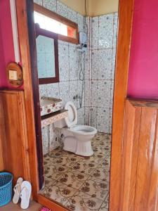 a small bathroom with a toilet and a mirror at Phanyro Motel in Sen Monorom