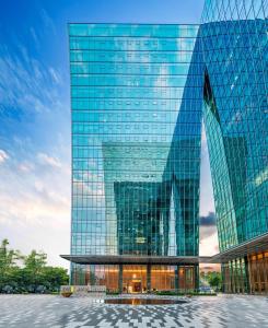wysoki szklany budynek z mnóstwem okien w obiekcie Home2 Suites by Hilton Shenzhen Nanshan Science & Technology Park w mieście Shenzhen