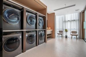 lavadero con 4 lavadoras y secadoras en Home2 Suites by Hilton Shenzhen Nanshan Science & Technology Park, en Shenzhen