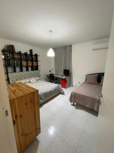 a bedroom with a bed and a desk in it at Merola Sisters Holiday Home in Caserta