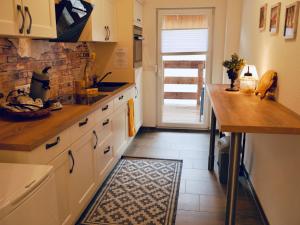 Una cocina con gabinetes blancos y piso de baldosas. en FeWo Fichte mit Balkon #Netflix #Innestadtnähe von Harztraveler, en Bad Harzburg 9 fotos más